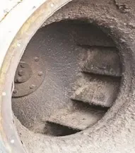 Debris accumulated on fan blades or rotor causing uneven mass distribution and imbalance